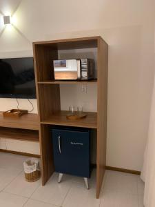 a room with a shelf with a microwave on it at Pérola do Tree Bies Resort in Entre Rios