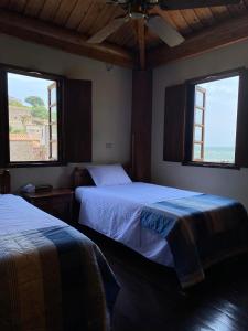two beds in a room with two windows at Jin Sha Ting Hai Homestay I in Nangan