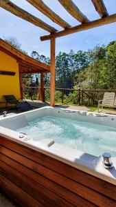 a jacuzzi tub sitting under a pergola at A Casa da Fazenda in Santo Antônio do Pinhal