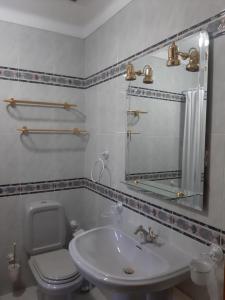 a bathroom with a sink and a toilet and a mirror at Casas do Patrão III Apartamento T2 in Sabugueiro