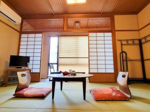 a living room with a table and two chairs at 和みの宿　おりがみ in Nagasaki