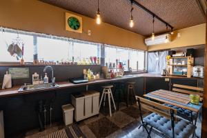 un bar en un restaurante con barra y mesa en HOJO MACHI HOSTEL, en Kasai