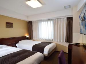 a hotel room with two beds and a window at APA Hotel Haneda Anamori Inari Ekimae in Tokyo