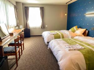 a hotel room with two beds and a mirror at 和みの宿　おりがみ in Nagasaki