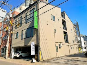 un edificio con un'auto parcheggiata di fronte di 和みの宿　おりがみ a Nagasaki
