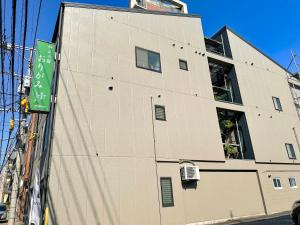 a building with a green sign on the side of it at 和みの宿　おりがみ in Nagasaki