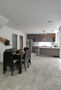 un soggiorno con tavolo e sedie e una cucina di Villa del Gualí #1 a Santa Fe de Antioquia