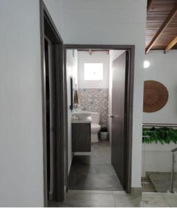 bagno con servizi igienici, lavandino e porta di Villa del Gualí #1 a Santa Fe de Antioquia