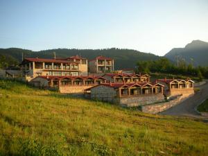 a large building on a hill in a field at Ipsivaton Mountain Resort in Moúcha