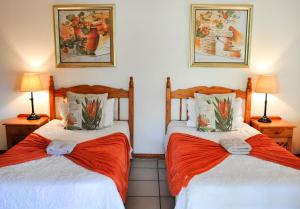 two beds in a room with two lamps at Annas Bed and Breakfast in St Lucia