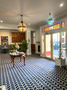 eine Lobby mit einem Tisch und einer Glastür in der Unterkunft Romano's Hotel & Suites Wagga Wagga in Wagga Wagga