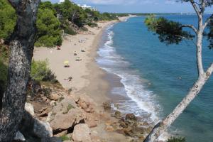 a beach with people laying on the sand and the water at Lovely villa in family resort in Miami Platja