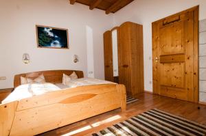 1 dormitorio con cama de madera y puerta de madera en Ferienwohnung Maria Erlsbacher, en Sankt Veit in Defereggen