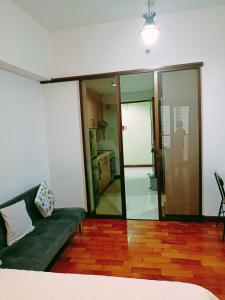 een woonkamer met een groene bank en glazen wanden bij 14d mosaic staycation in Manilla