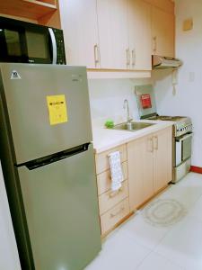 een keuken met een koelkast en een wastafel bij 14d mosaic staycation in Manilla