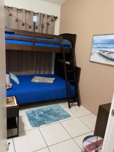 um quarto com 2 beliches e lençóis azuis em VILLA SEA BEACH em Aguada