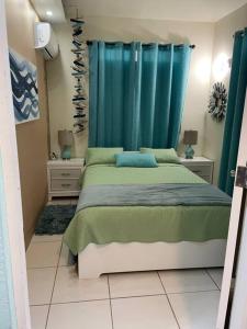 a bedroom with a bed with a blue curtain at VILLA SEA BEACH in Aguada