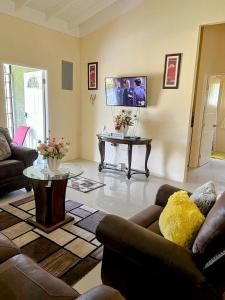 a living room with a couch and a table at L&V Paradise Vacation Home with Pool and Gym in The Rock