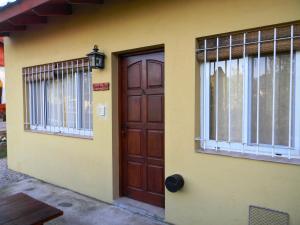 uma casa com uma porta castanha e uma janela em Samai Mayu em Los Reartes