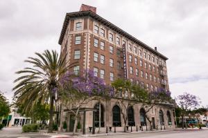 a tall brick building with purple flowers in front of it at The Culver Hotel in Los Angeles