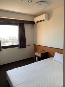 ein Hotelzimmer mit 2 Betten und einem Fenster in der Unterkunft Ogaki Hiyori Hotel - Vacation STAY 90822v in Ōgaki