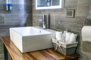 uma casa de banho com um lavatório branco e uma cesta de toalhas em Casa Montana Hotel em Chichicastenango