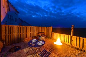 a patio with a table with a light on it at Mallow Cottage in Camber