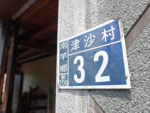 a street sign on the side of a building at Jin Sha Ting Hai Homestay I in Nangan