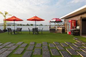 een patio met tafels, stoelen en parasols bij The Smith House in Pantai Cenang