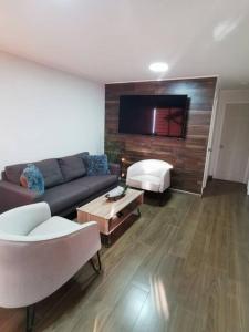 a living room with a couch and a flat screen tv at Casa Especial in Puerto Natales
