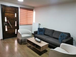 ein Wohnzimmer mit einem schwarzen Sofa und einem Tisch in der Unterkunft Casa Especial in Puerto Natales