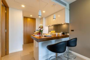 a kitchen with a counter and two stools at Oceanstone by RESAVA in Bang Tao Beach +10 photos