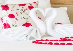 two white swans on a bed with roses at Keerawadee Two Bedroom House 