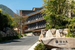 a building with a stone bench in front of a road at Hakone Gora KARAKU in Hakone