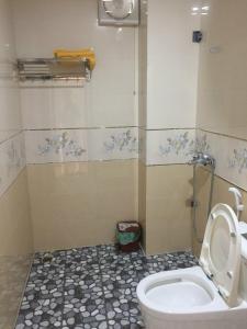 a bathroom with a white toilet and a shower at HT Homestay CAT BA in Cat Ba