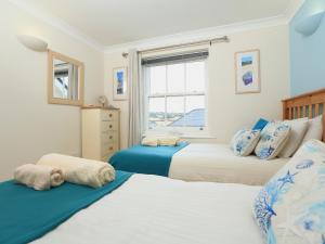 a bedroom with two beds and a window at 8 Thurlestone Beach in Thurlestone