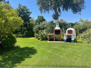 a garden with an outdoor oven in the grass at Attached quaint Farmhouse in Montemor o Novo with Swimming Pool in Montemor-o-Novo