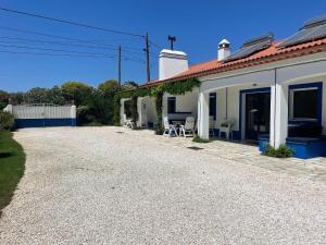 a house with a gravel driveway in front of it at Attached quaint Farmhouse in Montemor o Novo with Swimming Pool in Montemor-o-Novo