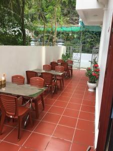 a restaurant with tables and chairs on a patio at HT Homestay CAT BA in Cat Ba
