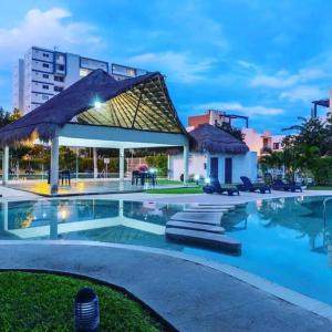 a swimming pool with a pavilion in a city at Apartamento exclusivo piscina, jaccuzi, céntrico. in Cancún