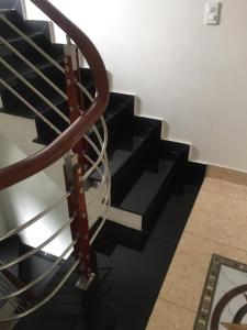a spiral staircase with black steps and a metal railing at HT Homestay CAT BA in Cat Ba