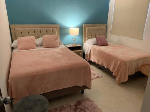 two beds sitting next to each other in a room at Apartamento exclusivo piscina, jaccuzi, céntrico. in Cancún +15 photos