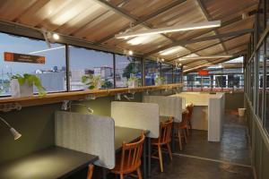 a restaurant with tables and chairs and windows at Tuju Abuserin Syariah in Jakarta