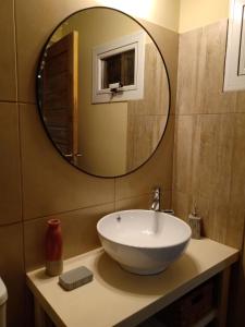 ein Badezimmer mit einem Waschbecken und einem großen Spiegel in der Unterkunft Balcón al Piltri Casa de Montaña in El Bolsón