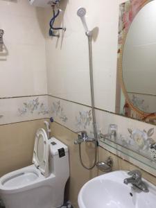 y baño con aseo, lavabo y espejo. en HT Homestay CAT BA, en Cat Ba