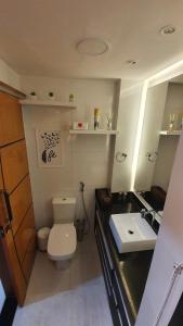 a bathroom with a toilet and a sink at Apto Duplex, Peró - Cabo Frio. Conforto, Piscina, Beira Mar. in Cabo Frio