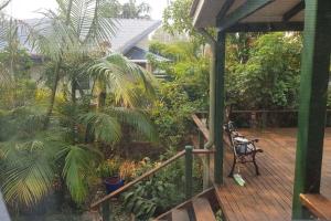 a porch with a deck with a bench and plants at Mullumbimby Studio in Mullumbimby