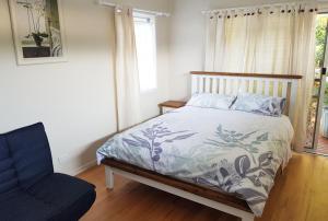 a bedroom with a bed and a chair and a window at Mullumbimby Studio in Mullumbimby
