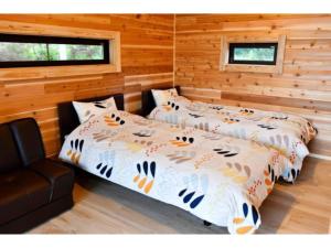 2 camas en una habitación con paredes de madera en Polar Haus NishiKaruisawa1 - Vacation STAY 87981v en Oiwake