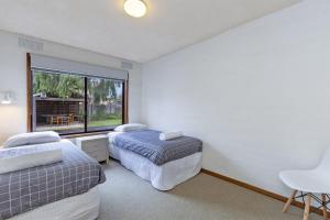 a bedroom with two beds and a large window at Eastern Beach Unit 1 in Port Fairy